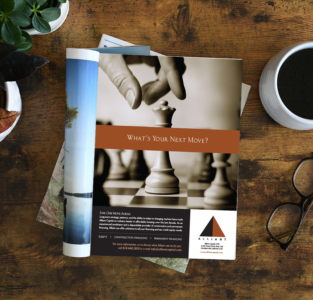 An open magazine laying on a table or desk with a white blank pa